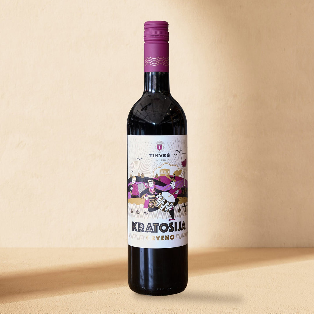 A bottle of Kratošija standing against a cream wall in soft window light