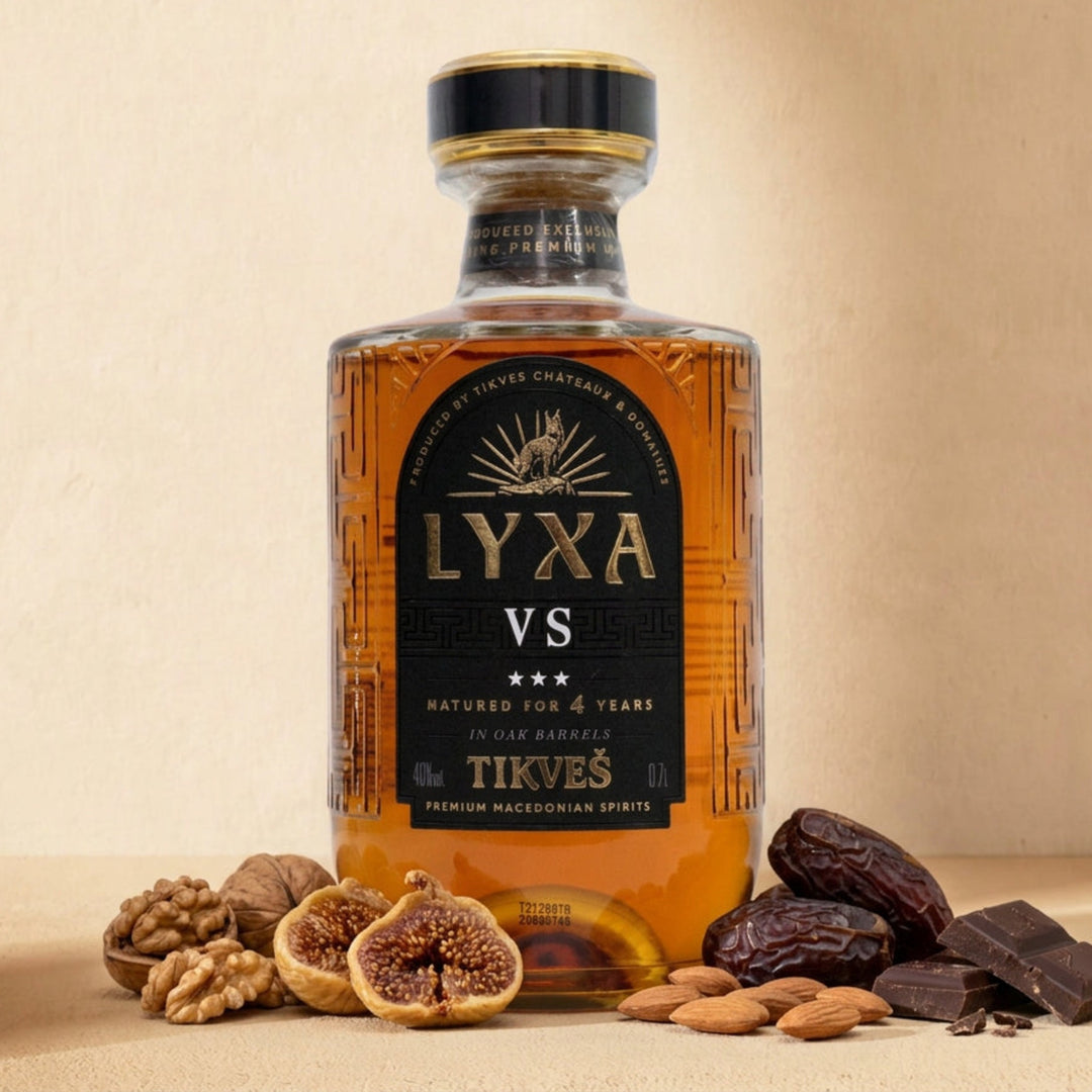 A bottle of LYXA VS grape brandy on a warm cream surface with walnuts, dried figs, dates, almonds and dark chocolate