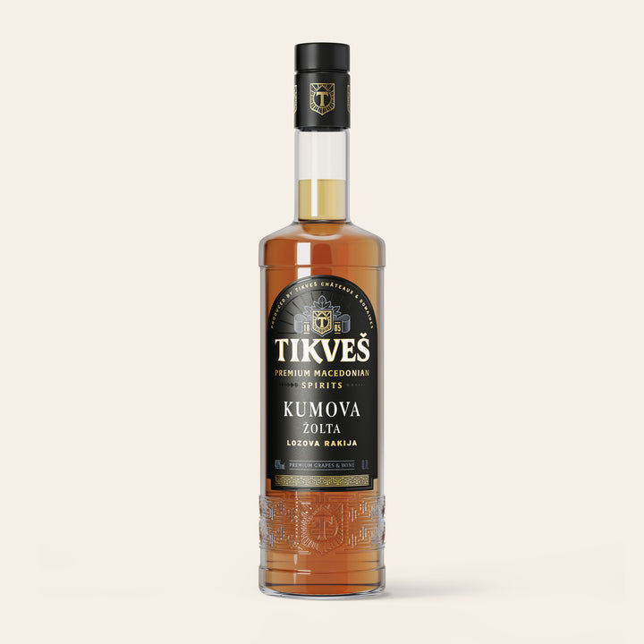Bottle of Kumova Žolta, a pale amber Macedonian rakija made from grapes, on a cream background