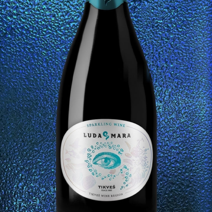 A bottle of Luda Mara Sparkling against a shimmering blue background