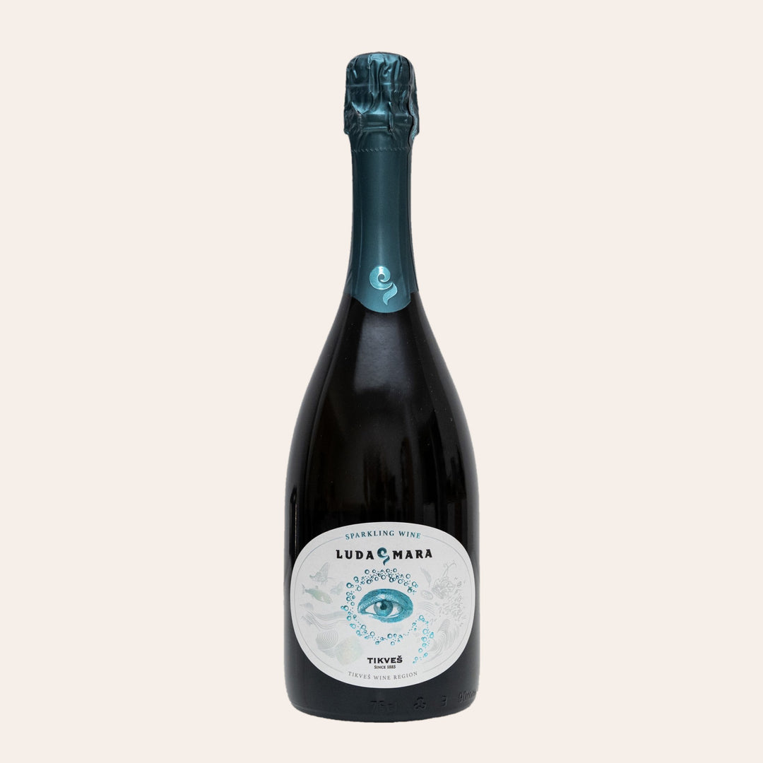 Bottle of Tikveš Luda Mara Sparkling, a dry brut sparkling wine, on a cream background